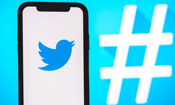 Logo de la aplicación de Twitter en la pantalla del smartphone con hashtag . —  Fotos de Stock