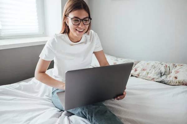 Unga leende kvinna använder laptop. — Stockfoto