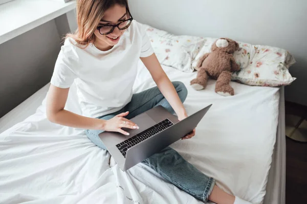 웃는 젊은 여성 이 노트북을 사용 한다. — 스톡 사진