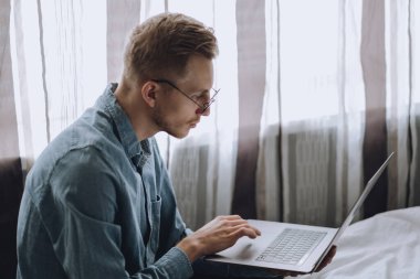 Serbest çalışan bir adam dizüstü bilgisayarla çalışıyor..