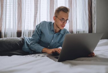 Serbest çalışan bir adam dizüstü bilgisayarla çalışıyor..