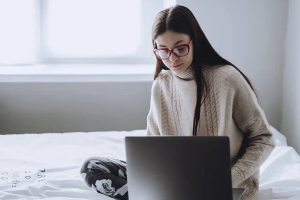 Nő az ágyon napközben dolgozik egy laptop. — Stock Fotó