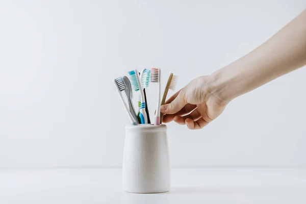 Different types of toothbrushes in a white cup. — Stock Photo, Image