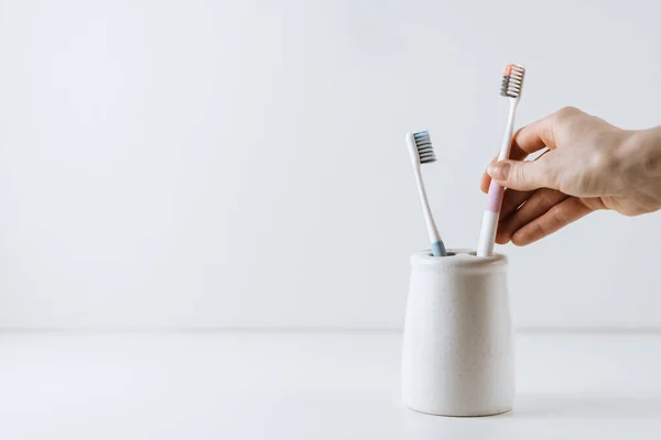 Different types of toothbrushes in a white cup. — Stock Photo, Image