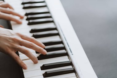 Midi klavyesinde piyano çalan bir piyanist.