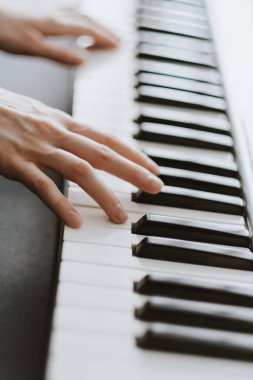 Midi klavyesinde piyano çalan bir piyanist.