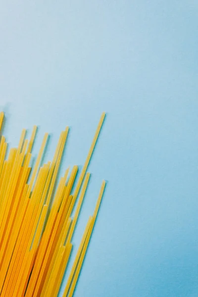 Spaghetti di pasta di frumento isolati su fondo blu . — Foto Stock