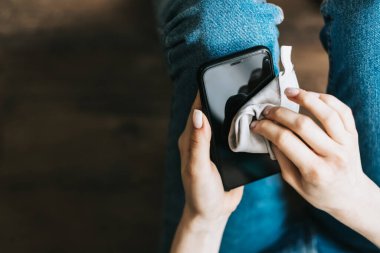 Dış faktörlerden alınan lifli kumaşla akıllı telefon ekranını temizlemek.