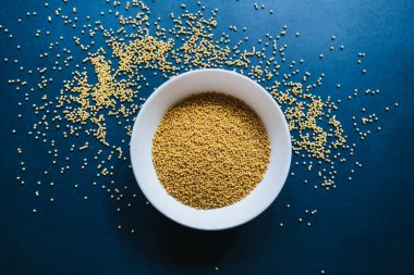 Mavi arka planda beyaz tabakta Millet lapası. 