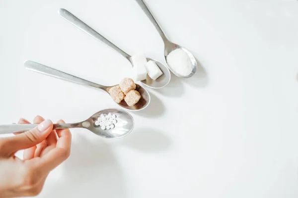 Different types of sugar, the hand holds a spoon with a sugar substitute — Stock Photo, Image