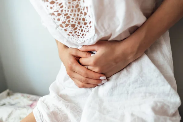 Young woman standing holding belly suffering. Pain. — Stock Photo, Image