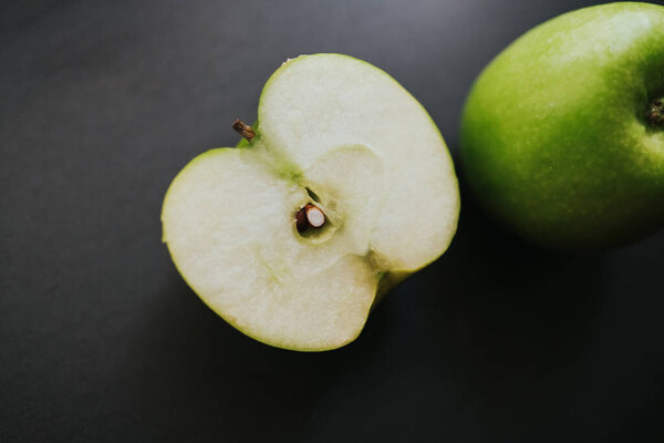 Зеленое яблоко в каплях воды на черном фоне
. 