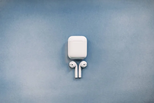 Apple AirPods draadloze hoofdtelefoon met oplaadvak op de achtergrond. — Stockfoto