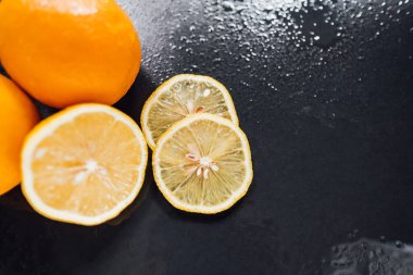 Taze portakallar ve koyu arkaplanda limon. . 