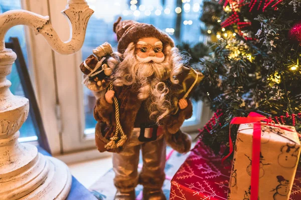 Noel Baba oyuncağı Noel ağacının yanında hediyelerle. 