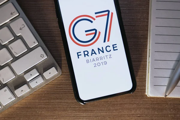 IPhone X с логотипом саммита G7 2019 во Франции на экране . — стоковое фото