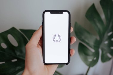 Ekranda Vsco Cam uygulaması olan iPhone X 'i tutan eller.
