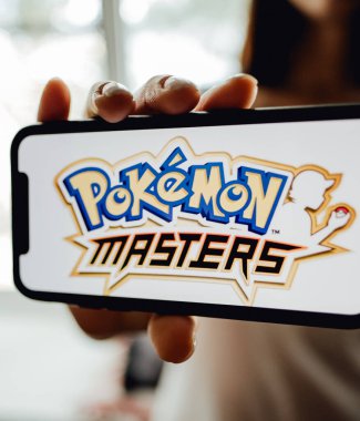 Ekranda pokemon ustaları olan iPhone 'u tutan eller.