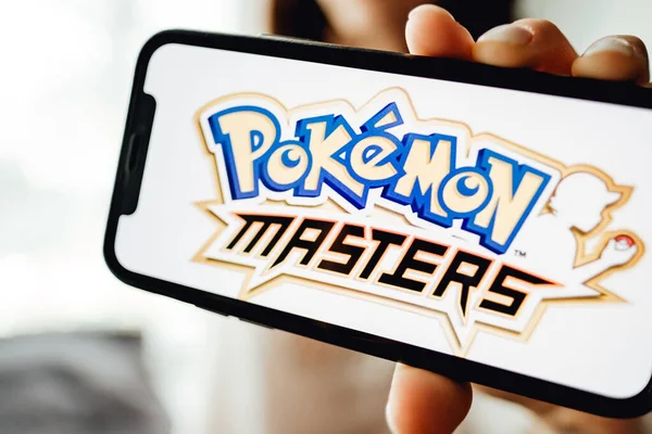 Χέρια κρατώντας το iPhone με τους πλοιάρχους Pokemon στην οθόνη. — Φωτογραφία Αρχείου