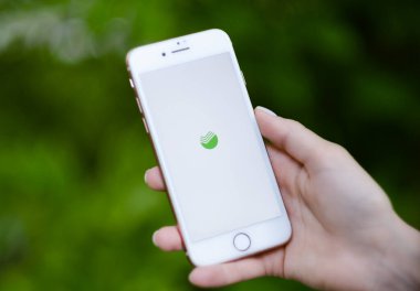  Sberbank Çevrimiçi uygulaması ekranlı iPhone 'u tutan eller. 