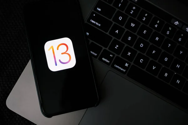 IPhone и MacBook с логотипом iOS 13 на экране . — стоковое фото