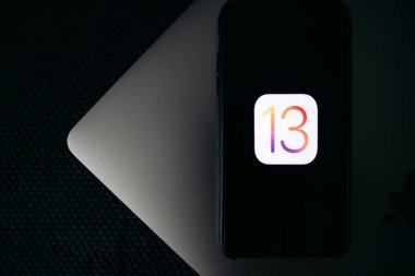 iPhone ve MacBook 'ta iOS 13 logosu ekranda.