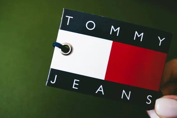 Closeup of Tommy Hilfiger label on green background . — Stock Photo, Image