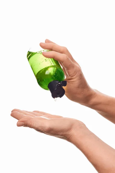 Beyaz arka planda el dezenfektanı kullanan kadın eller.