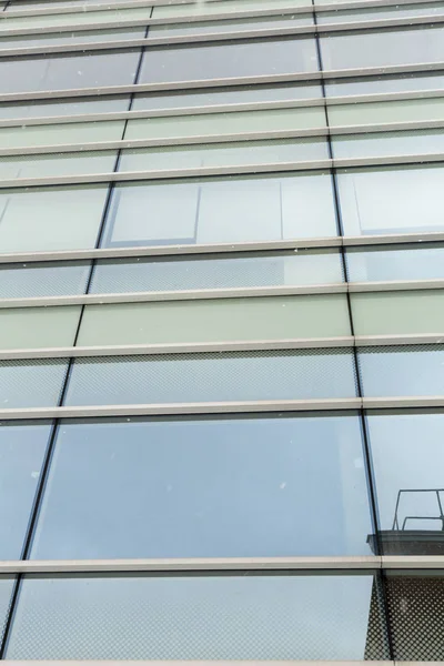 Ventanas de vidrio del edificio de negocios durante una nevada — Foto de Stock