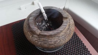 Bir Kül tablasında sigara içiyor