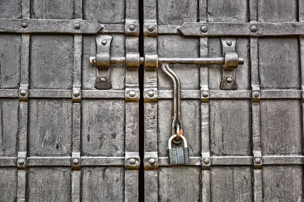 The lock hangs on a wrought iron gate Stock Image