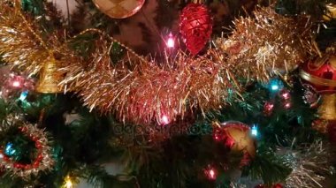 Parlak oyuncakları ve yanıp sönen renkli çelengi olan Noel ağacı.