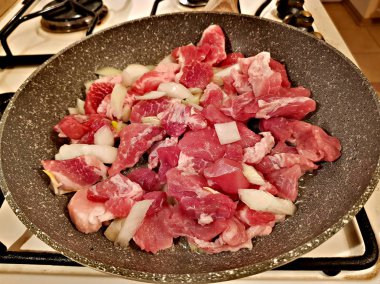 Bir tavada et parçaları kızarmış dilimlenmiş