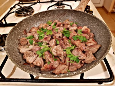 Bir tavada et parçaları kızarmış dilimlenmiş