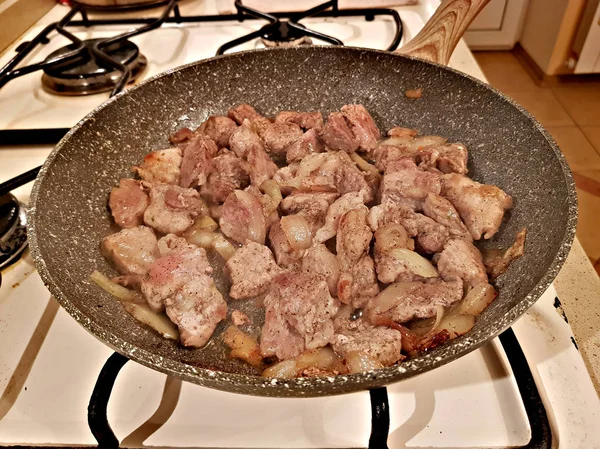 Les morceaux de viande tranchés sont frits dans une poêle — Photo