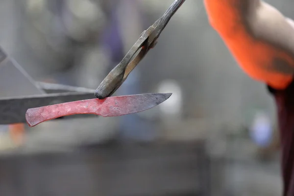 Un herrero demuestra una pieza de metal forjado — Foto de Stock