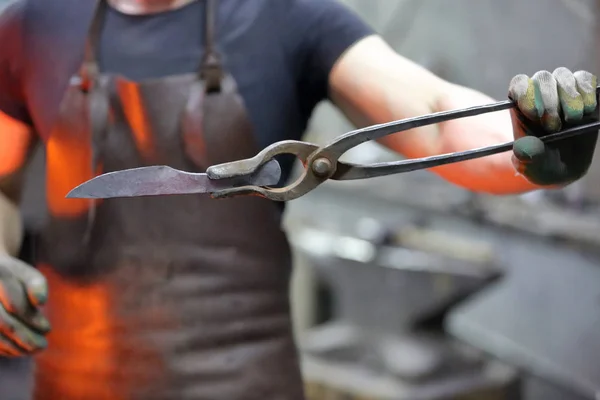 Un herrero demuestra una pieza de metal forjado —  Fotos de Stock