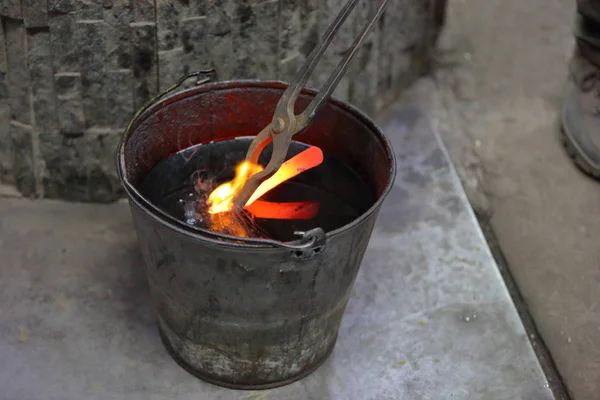 Kühlung eines Metallbarrens in Motoröl — Stockfoto