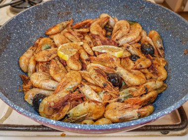 Tavada kızarmış zeytinli karides.