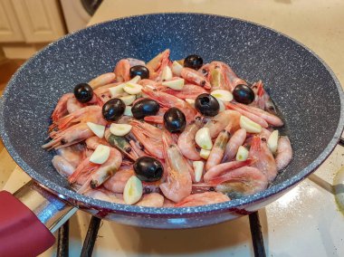 Tavada kızarmış zeytinli karides.