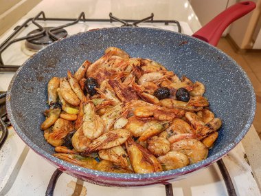 Tavada kızarmış zeytinli karides.