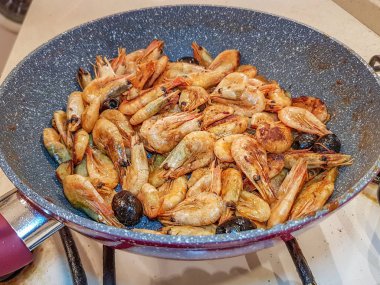 Tavada kızarmış zeytinli karides.