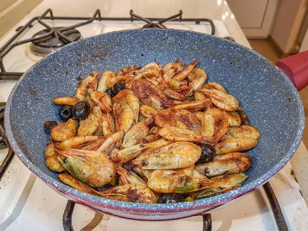 Gamberetti con olive fritte in una padella — Foto Stock