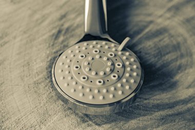 Doğal ahşap arka planda metalik renkli plastikten yapılmış yuvarlak duş başlığı