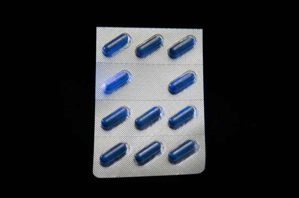 Capsule Mediche Ovali Blu Confezione Plastica Argentata Fondo Nero — Foto Stock