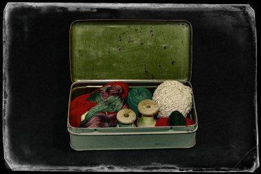 Eski metal bir kutuda dikiş ve el işi için klasik iplikler.