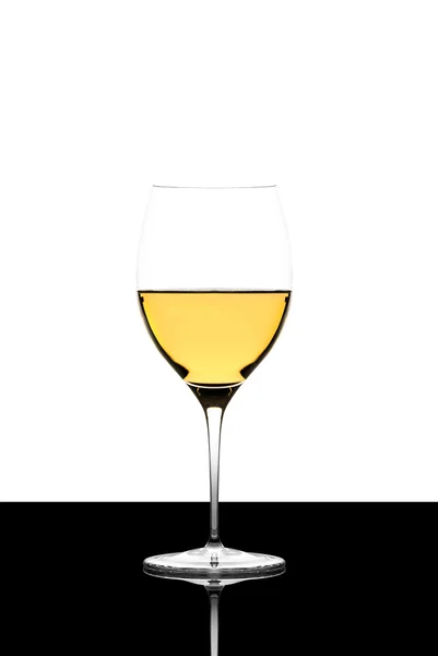 White wine glass on a  black board isolated and backlit and refl — Stock Photo, Image