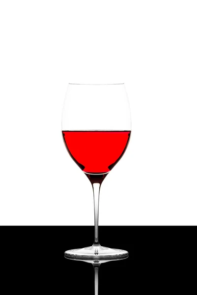 Red wine glass on a  black board isolated and backlit — Stock Photo, Image