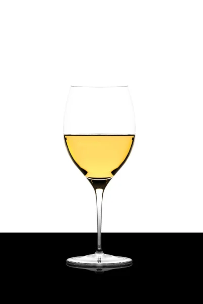 Copa de vino blanco en una pizarra negra aislada y retroiluminada — Foto de Stock