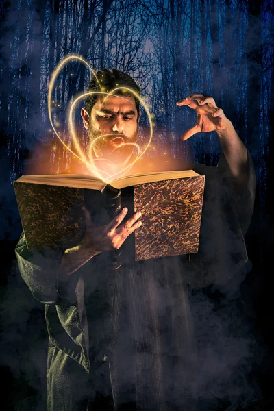 Male sorcerer casting a spell from a magic book as halloween ima